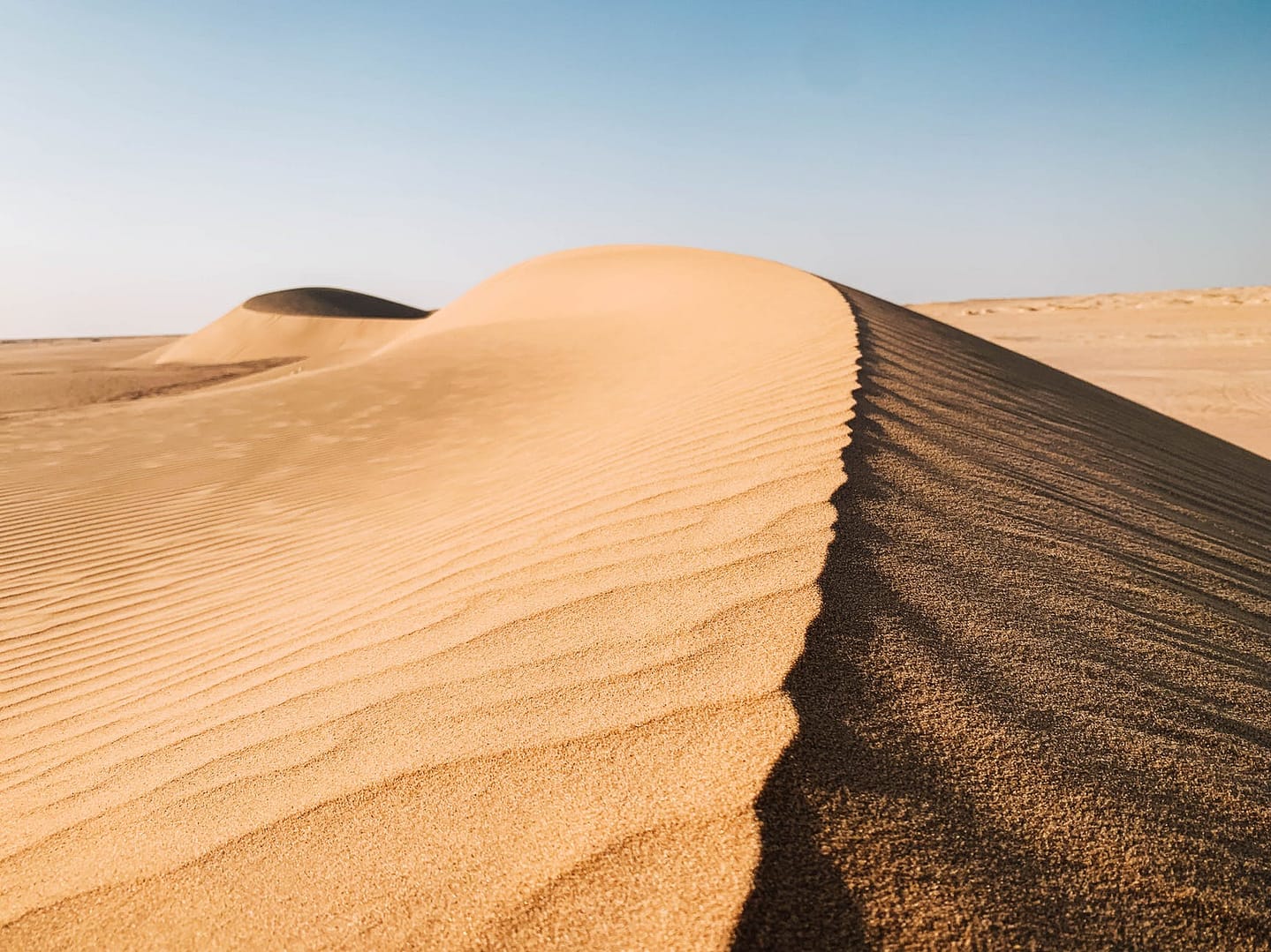 brown sand under blue sky