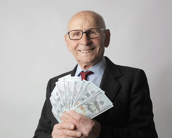 man in black suit holding dollar bills